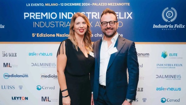 Daniele Salamina e una donna in abito nero davanti al pannello del Premio Industria Felix: Milano, 12 dicembre 2024, Palazzo Mezzanotte