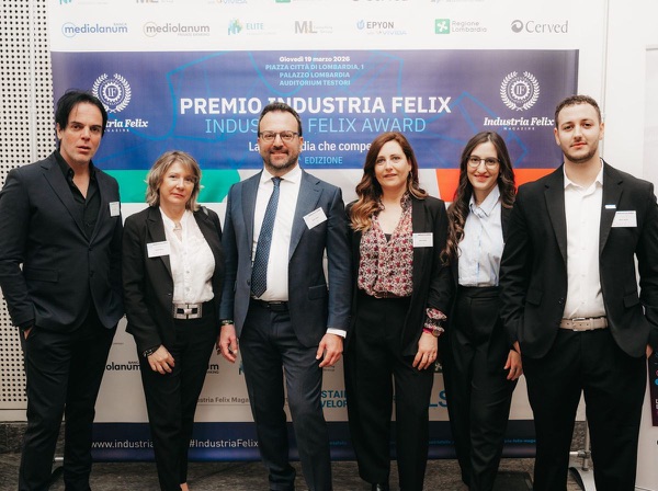 Sei persone della squadra ONYX davanti al pannello del Premio Industria Felix, giovedì 19 marzo 2026, Palazzo Lombardia
