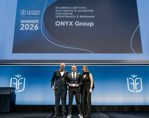 Daniele Salamina col trofeo sul palco di Le Fonti Awards; sullo schermo: Winner 2026, Eccellenza dell'Anno, Innovazione & Leadership, Formazione Settori Beauty & Benessere, ONYX Group