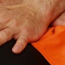 Mani che lavorano sulla spalla di un atleta