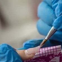 Mani con i guanti blu che stendono il gel su una cartina