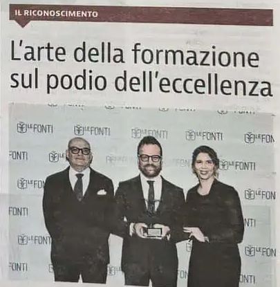 La stessa pagina, fotografata: il riquadro «L'arte della formazione sul podio dell'eccellenza» e la foto della premiazione di Le Fonti Awards, con Daniele che tiene il trofeo