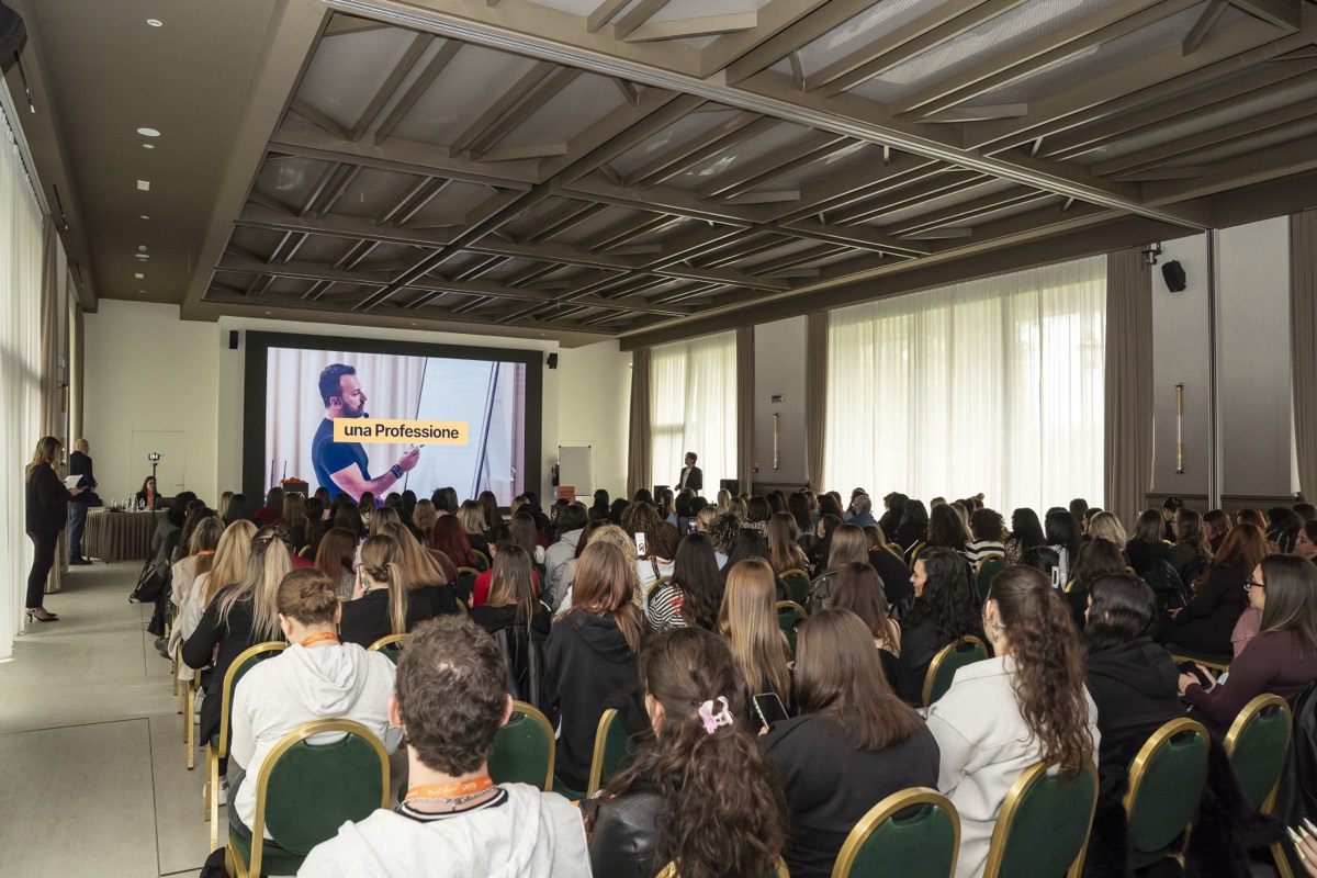 Il pubblico di un incontro ONYX Academy visto di lato, con il relatore sullo schermo