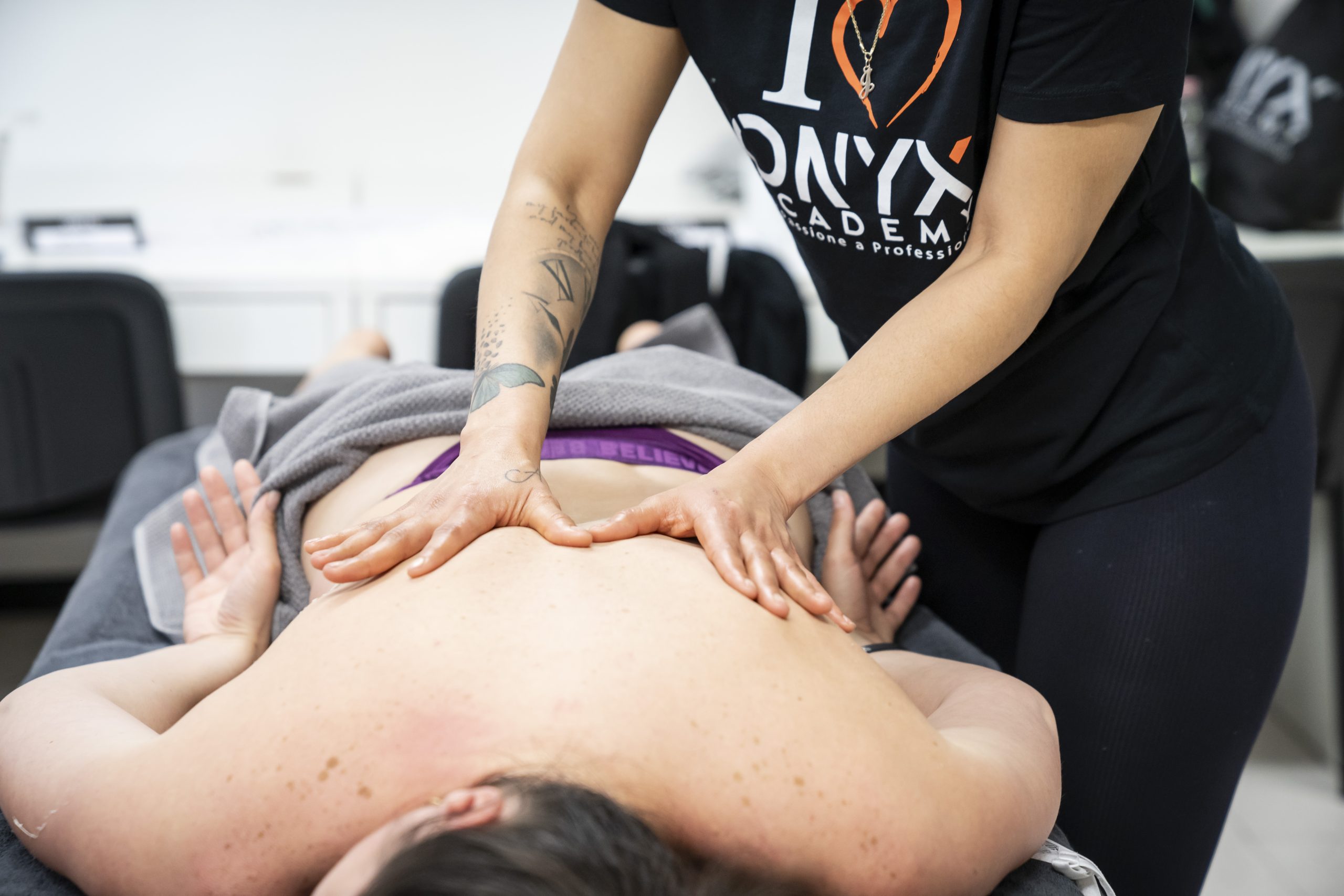 Massaggiatore che palpa la schiena per individuare i trigger point lungo i muscoli paravertebrali